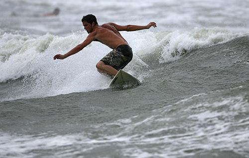 A surfer in Galveston, Texas, braves the choppy surf brought on by Tropical Storm Humberto formed in the Gulf of Mexico on Wednesday. THE ASSOCIATED PRESS, SHARON STEINMANN
