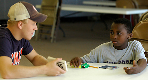 Sophomore Ian Anderson in LAS helps Jonathan Nengo, 10, with his math skills at St. Matthew Lutheran Church in Urbana on Saturday. Anderson is a member of the Alpha Phi Omega Service Fraternity which is sponsoring the Ugly Man on Campus pageant to fund Erica Magda
