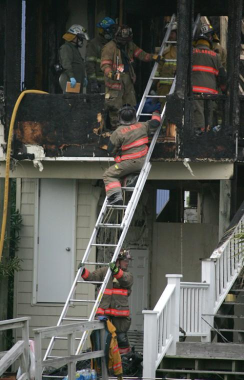 Firefighters work the scene of a fatal fire from the back of a beach house in Ocean Isle Beach, N.C., Sunday. Erica Magda
