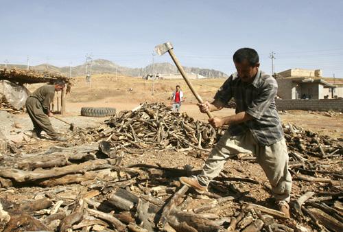 Kurdish men chop wood in Beagova village near the Turkish border on Thursday. Their families were displaced a week ago when Turkish artillery destroyed their homes. Turkey has threatened an incursion into northern Iraq if Iraqi Kurds and U.S. forces do no Erica Magda
