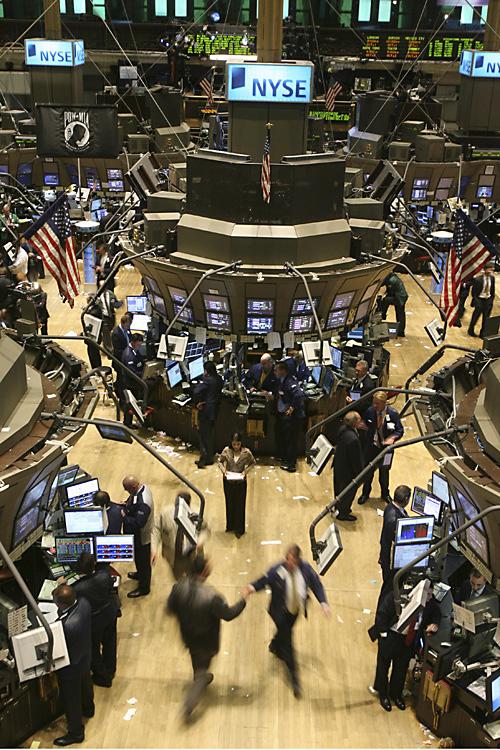 Traders high-five on the floor of the New York Stock Exchange shortly after the closing bell on Monday. THE ASSOCIATED PRESS, MARY ALTAFFER
