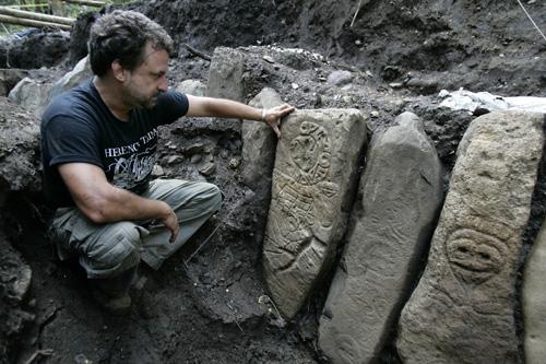 Puerto Rican archaeologist Hernan Bustelo sits next stones etched with ancient petroglyphs and graves that reveal unusual burial methods in Ponce, Puerto Rico, on Tuesday. Laura Prusik
