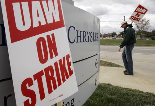 United Auto Worker Scott Smith carries a strike sign outside the Chrysler Warren Stamping facility in Warren, Mich. THE ASSOCIATED PRESS, PAUL SANCYA
