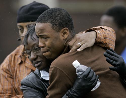People embrace outside the SuccessTech Academy on Wednesday in Cleveland. A gunman opened fire at the alternative school. THE ASSOCIATED PRESS, TONY DEJAK
