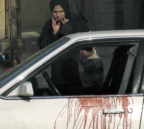 A woman and a child inspect a car with blood splattered on the door after two Christian Iraqi women were shot to death in central Karradah, Baghdad, Iraq, on Tuesday, Oct. 9, 2007. Iraqi police, and witnesses said that the men who shot them were in a conv THE ASSOCIATED PRESS
