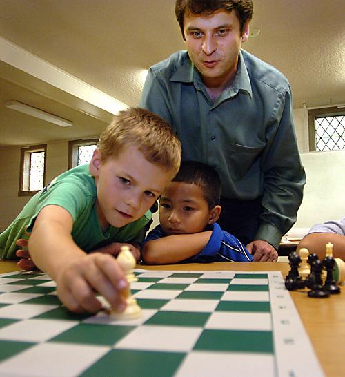 Yury Shulman teaches Joshua Kurtzer, left, and Tristan Cooper, at the St. Matthew Lutheran Church chess club in Hawthorn Woods, Ill., on Sept. 20. THE ASSOCIATED PRESS, PAUL VALADE
