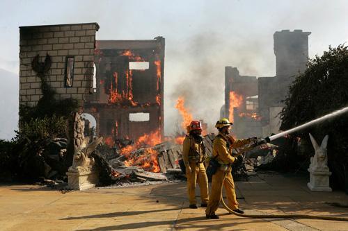 A firefighter works to control a backfire set in Running Springs, Calif., on Wednesday. Property damage has reached $1 billion in San Diego County alone. Laura Prusik
