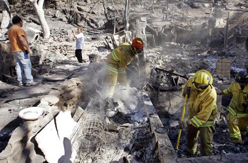Brian and Sue Geraci view the remains of their burned-out Modjeska Canyon, Calif., home for the first time Tuesday. Mark J. Terril, The Associated Press
