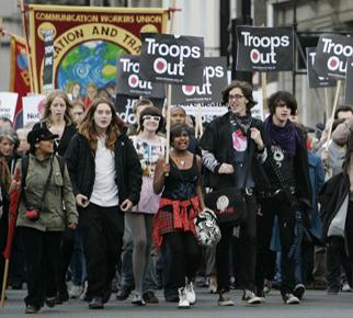 Anti-war protesters march along a central London street near the Houses of Parliament on Monday. Prime Minister Gordon Brown said Monday that Britain will withdraw nearly half of its troops from Iraq beginning spring of 2008. THE ASSOCIATED PRESS, LEFTERIS PITARAKIS
