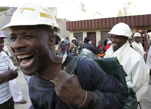 Two of the miners who were trapped overnight, smile as they are greeted at the Elandsrand Gold mine near Carletonville, South Africa, Thursday, Oct. 4, 2007. More than 1,700 trapped gold miners have been rescued during a dramatic all-night operation and e THE ASSOCIATED PRESS, SCHALK VAN ZUYDAM

