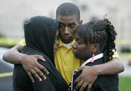Family members hug outside the SuccessTech Academy Wednesday in Cleveland. A gunman opened fire Wednesday at the alternative school, and three children were taken to a hospital, the mayor said. THE ASSOCIATED PRESS, TONY DEJAK

