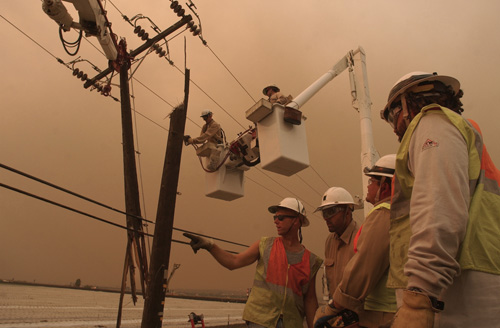 Southern California Edison foreman Mark Hubbard, left, talks with crew members while linemen Brandon Hyatt, above left, and Mitch Ogg, above right, work on a power pole damaged by strong winds in Camarillo, Calif, on Oct. 21. From the high desert to the P Erica Magda
