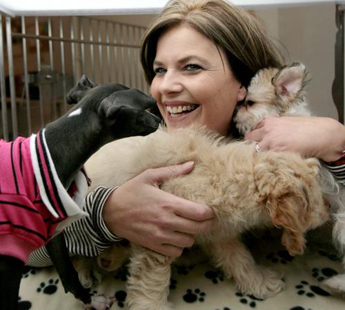 Shop owner Kari Pryor, resident of Sidney, Ill., is playing with the puppies at the Lucky Puppy Boutique and Barkery, located at the Marketplace Mall. Erica Magda
