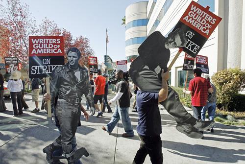 Striking writers picket with life-size photos of legendary actors, Marlon Brando, left, and James Dean. The protest took place Monday in Los Angeles. Damian Dovarganes, The Associated Press
