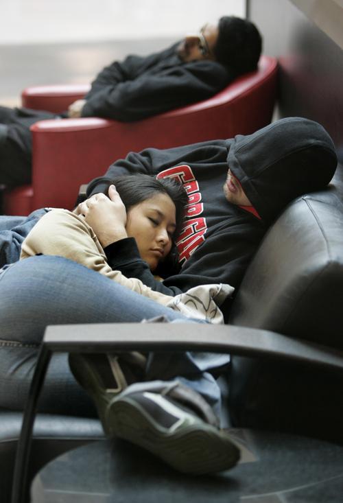 Nelly Su, of Miami, rests in the arms of her sleeping boyfriend Mike Thomas, as Satish Venkat, rear, also tries to nap before their flights out of Hartsfield-Jackson International Airport, Monday, Nov. 26, 2007, in Atlanta. Su missed her flight to Miami w John Amis, The Associated Press
