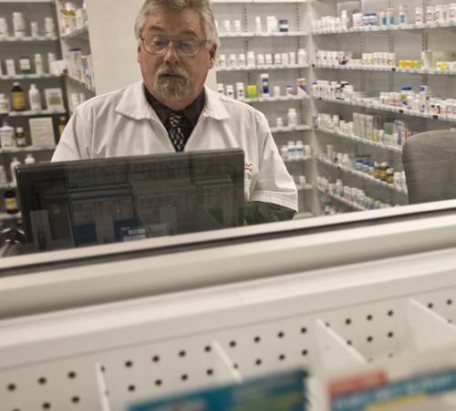 Rick Ingram, Schnucks pharmacy manager, types up a prescription at its location in Savoy, Thursday. Schnucks recently launched a prescription antibiotic plan that allows people to get a 21-day supply of 54 different generic oral antibiotics free of charge Erica Magda
