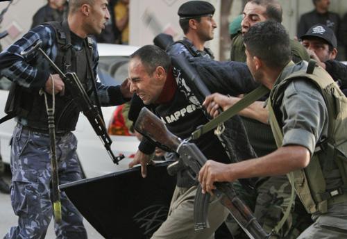 Palestinian police officers beat a protester during a protest against the U.S. sponsored Annapolis meeting in the West Bank city of Hebron, Tuesday. Hisham Baradiyeh, a 36-year-old member of the Islamic group The Liberation Party, was shot in the chest. T Nasser Shiyoukhi, The Associated Press
