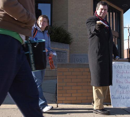 Rev. Mike Mulberry, right, pastor of Community United Church of Christ in Champaign and Susan Requa, senior in LAS, offer a bag of granola to a passing student outside the church on Wednesday. Mulberry has protested the war outside the church on Wednesday Erica Magda
