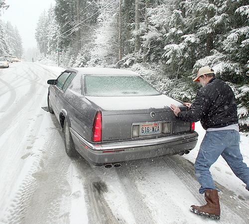 Good Samaritan Clay Dehsner, right, helps to keep a car on the slippery road away from the ditch after it got stuck, Sat. Dec. 1, 2007 in Camp Union, Wash. Snow and ice plastered a wide area of the Midwest on Saturday, interrupting campaigning by presiden Larry Steagall, The Associated Press
