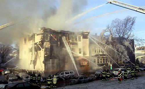 Firefighters battle a multifamily house fire caused after a gasoline truck overturned at a traffic circle Wednesday in Everett, Mass. The fire spread to at least two multifamily homes and ignited as many as 40 cars, but there were no reports of any deaths Bizuayehu Tesfaye, The Associated Press
