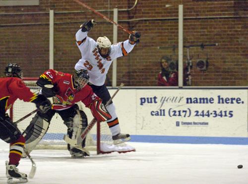Drew Heredia jumps over the Illinois State goalie at the Ice Arena on Friday. Erica Magda
