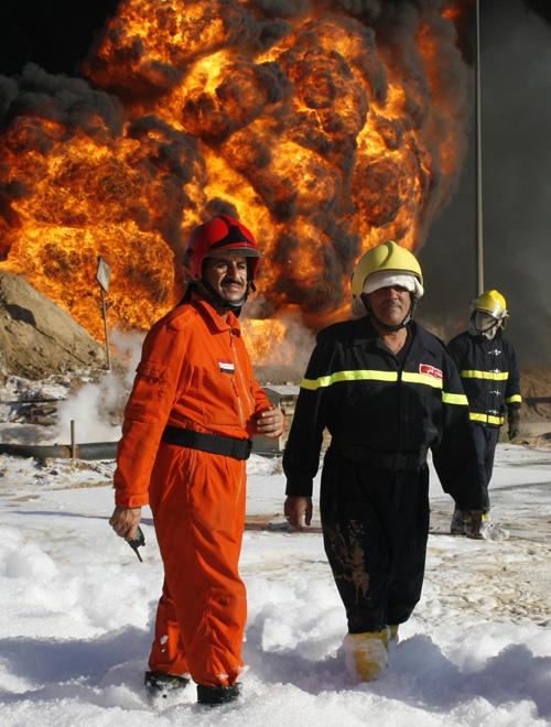 Firemen+stand+near+a+fire+at+the+al+Dora+oil+refinery+in+South+Baghdad%2C+Monday.+Iraqi+oil+officials+and+the+U.S.+military+initially+said+the+plant+had+come+under+indirect+fire%2C+the+military+term+for+mortars+or+rockets.+Loay+Hameed%2C+The+Associated+Press%0A