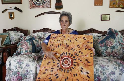 Aborigine Mari Melito Russell holds one of her paintings during an interview in Mount Druitt, Australia, on Wednesday. Mark Baker, The Associated Press
