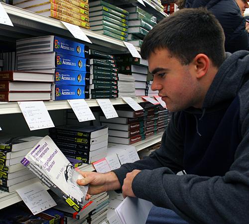 Drew Strellis, sophomore in Business, filters through the many shelves of books at the Illini Union Bookstore, Monday. With classes starting, the rush for books has started, leaving students to face long lines at the bookstores. IBX has presented a new wa Erica Magda
