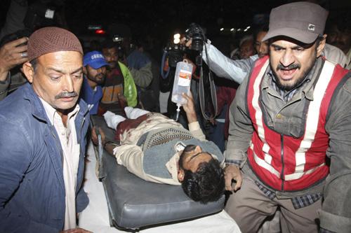 Pakistani volunteers carry a man injured in a blast to a local hospital in Karachi, Pakistan, Monday. A powerful bomb exploded, killing at least nine people and injuring many more. It was not immediately clear who was behind the blast. Islamic militants Fareed Khan, The Associated Press
