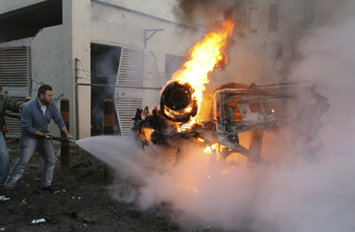 Firefighters try to extinguish a burning car at the site of an explosion in Beirut, Lebanon on Tuesday. An explosion targeted a U.S. Embassy vehicle Tuesday in northern Beirut, killing four Lebanese and injuring a local embassy employee, a U.S. official s Vartivar Karageuzian, The Associated Press
