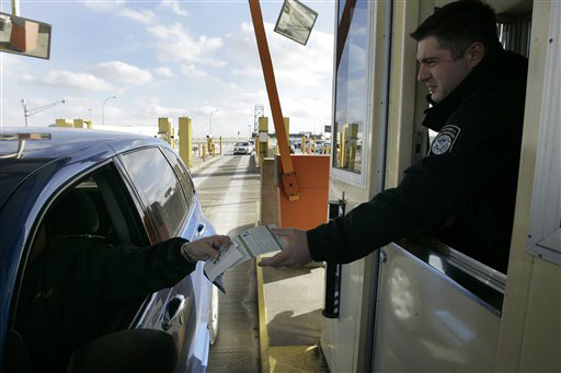 U.S. Customs officer Nick Ligerakis hands back a Michigan drivers license and information pamphlet to a driver arriving from Canada at the Ambassador Bridge in Detroit, Wednesday, Jan. 30, 2008. U.S. officials begin what amounts to a test run of new ident Paul Sancya, The Associated Press
