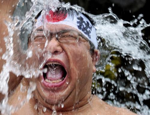 An well-wisher using wooden tubs splash cold waters onto himself during an annual cold-endurance festival at the Kanda Myojin shinto shrine in Tokyo, Saturday, Jan. 12, 2008. Itsuo Inouye, The Associated Press
