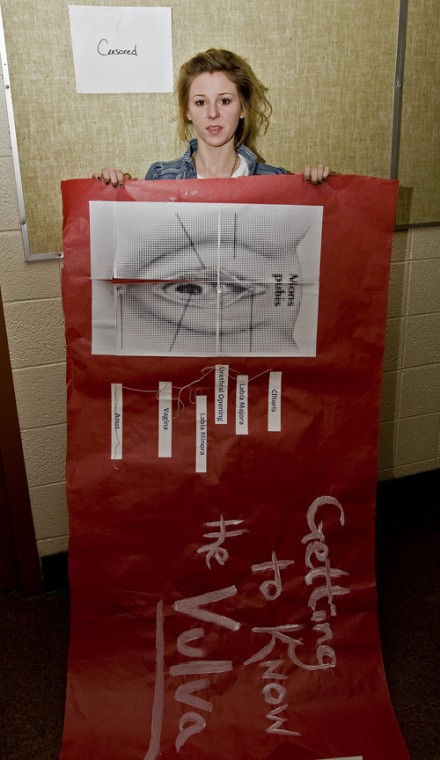 Beth Dunn, sophomore in LAS, takes down a poster about the vulva from Hopkins Hall, Monday. Erica Magda
