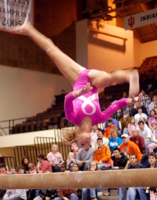Junior Julie Crall flips above the balance beam during her routine on Saturday at Huff Hall. Erica Magda
