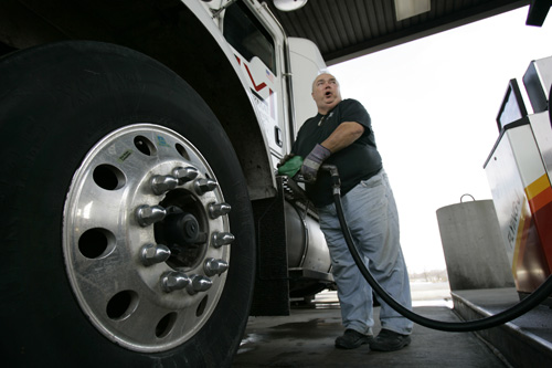 Truck driver Mike Monnin fills his tank with fuel at a cost of $3.959 per gallon at a truck stop in Pembroke, N.Y. David Duprey, The Associated Press
