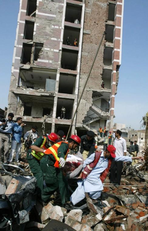 Pakistani rescue workers remove a dead body from the site of a suicide bombing at the office of the Federal Investigation Agency, Tuesday, March 11, 2008, in Lahore, Pakistan. Massive suicide bombs ripped through the seven-story police headquarters and a K.M. Chaudary, The Associated Press
