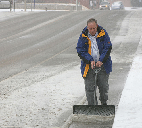 Lou Ryseff uses a shovel to clear away snow Tuesday in Belleville, Ill. Tim Vizer, The Associated Press
