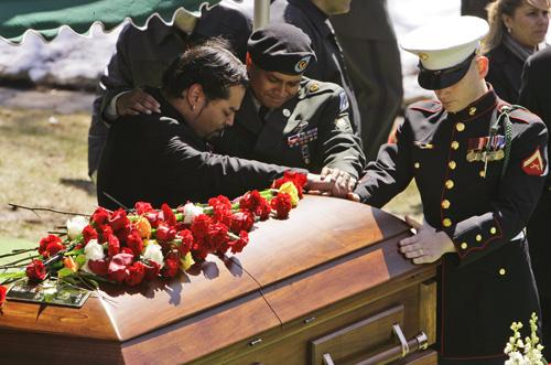 Lance Cpl. Alfredo Rivera (left), Spc. Edward Rivera and Carlos Figueroa (right) mourn over the coffin of Army Spc. Michael D. Rivera on March 21, 2007. Mary Altaffer, The Associated Press
