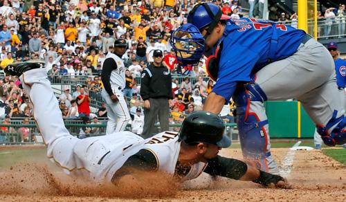 Pittsburgh Pirates third baseman Jose Bautista, left, reaches for the plate and avoids the tag by Chicago Cubs catcher Geovany Soto to tie the game in the seventh inning in Pittsburgh on Monday. The Cubs won 10-8 in 12 innings. Gene J. Puskar, The Associated Press
