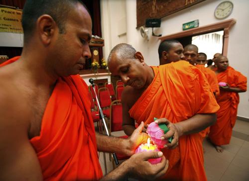 Buddhist monks light candles during special prayers at a temple in Kuala Lumpur, Malaysia, on Sunday. Vincent Thian, The Associated Press

