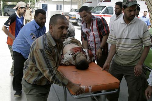 Iraqis rush a wounded man into a hospital in the Shiite enclave of Sadr City in Baghdad, Iraq, on Tuesday. The man, injured in recent violence, died a few minutes later according to hospital officials. Karim Kadim, The Associated Press
