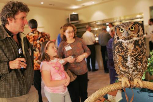 Guests look at a great horned owl during the Doodle for Animals auction and banquet in April 2007 at the Round Barn Banquet Ce
