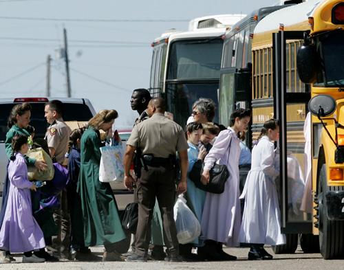 Law enforcement officials escort members of The Fundamentalist Church of Jesus Christ of Latter Day Saints onto a school bus in Eldorado, Texas, on Sunday. Authorities took 220 women and children from the compound. The group was relocated to San Angelo Tony Gutierrez, The Associated Press
