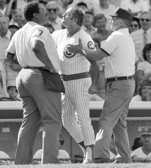 In this Aug. 17, 1982 photo, umpires try to calm Chicago Cubs manager Lee Elia, center, after a disputed call during a Cubs-Los Angeles Dodgers baseball game in Chicago. Elia is now donating to Chicago Baseball Cancer Charities. Jon Swart, The Associated Press
