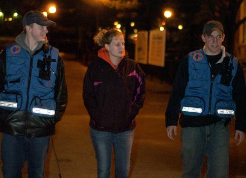 Sophomore Jeremiah Allen, left, and junior Jon Manko, right, student patrol officers for Safe Walks, accompany a student who wished not to be named back to her apartment on Tuesday around 11:30 p.m. Erica Magda
