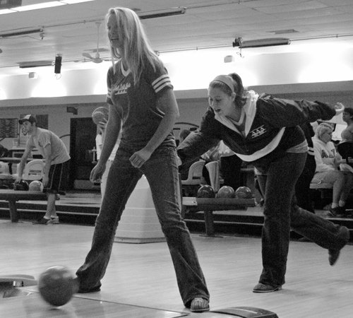 Representing Alpha Gamma Rho and Delta Delta Delta, Haley Nealey, junior in AHS, stands as Christy Thiel, freshman in LAS, bowls between her legs at the Greek Bowl charity event where the two chapters shared a lane. Ally Schlumpf
