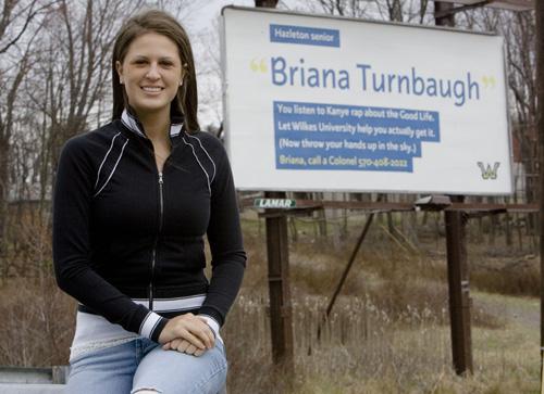 Briana Turnbaugh poses with a billboard with her name, placed by Wilkes University as a recruitment tool, in Hazleton, Pa., on April 20. Matt Rourke, The Associated Press
