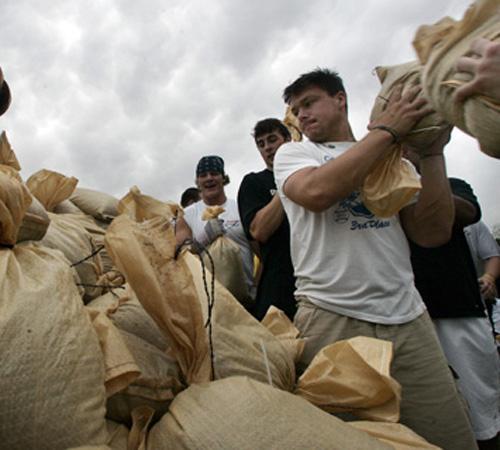 University of Iowa quarterback Jake Christensen, right, loads sand bags into a front end loader with other members of the team at the Coralville, Iowa, Streets Department facility Wednesday. Floodwaters in the Iowa City, Iowa, and Coralville areas continu Brian Ray, The Associated Press
