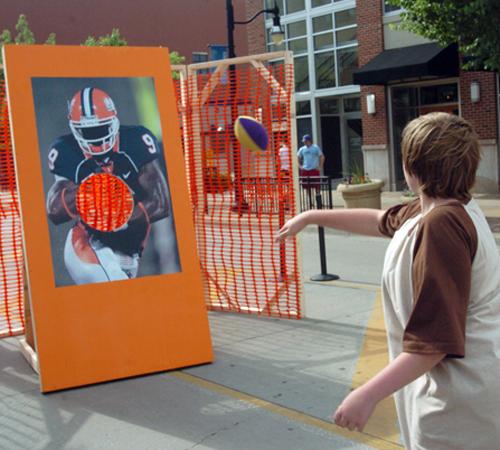 Ben Dixon, 11, throws a football at an Arrelious Benn throwing target outside of Gameday Sprit. Wes Anderson
