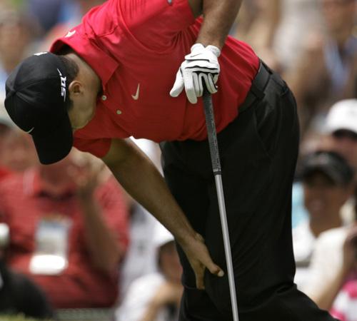 In this June 15 file photo, Tiger Woods holds on to his left knee after teeing off on the second hole during the fourth round of the US Open championship at Torrey Pines Golf Course in San Diego. Charlie Riedel, The Associated Press
